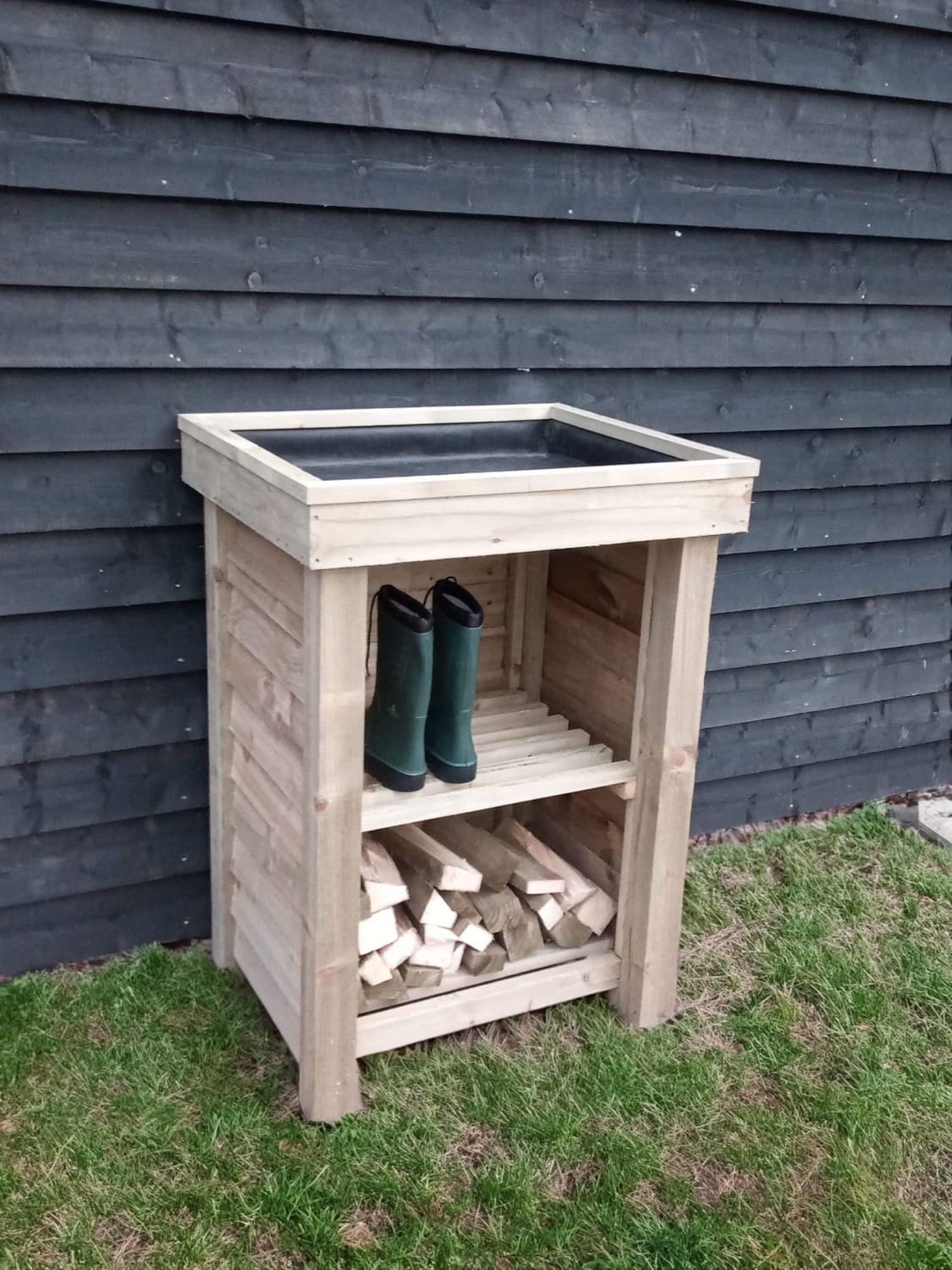 Handcrafted wooden planter with integrated log store by RA Garden Ideas. The top section can hold pots or plants, while the lower shelf provides space for boots, tools, or a bundle of logs.