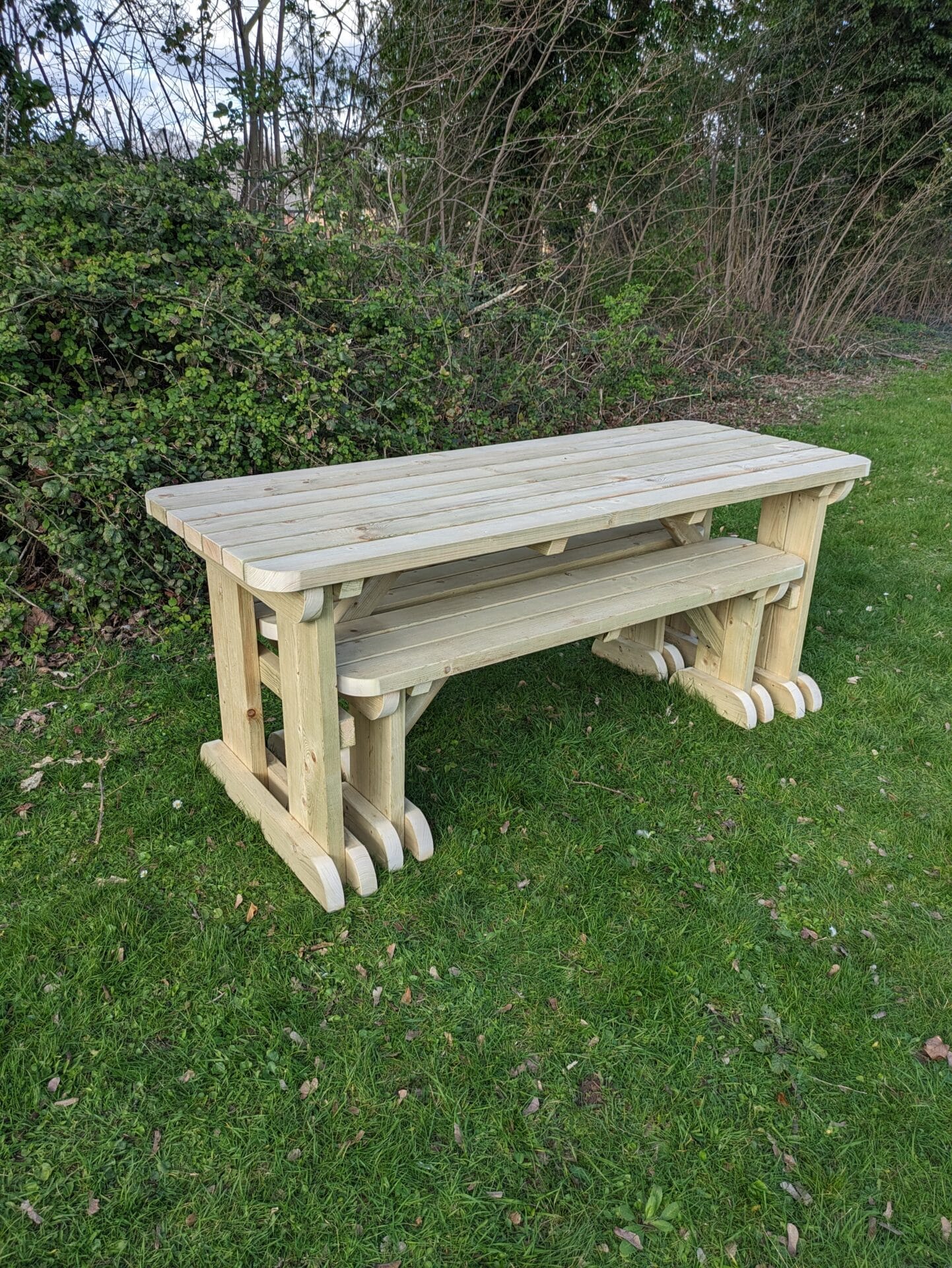 picnic table set with rounded edges, benches neatly stored underneath.
