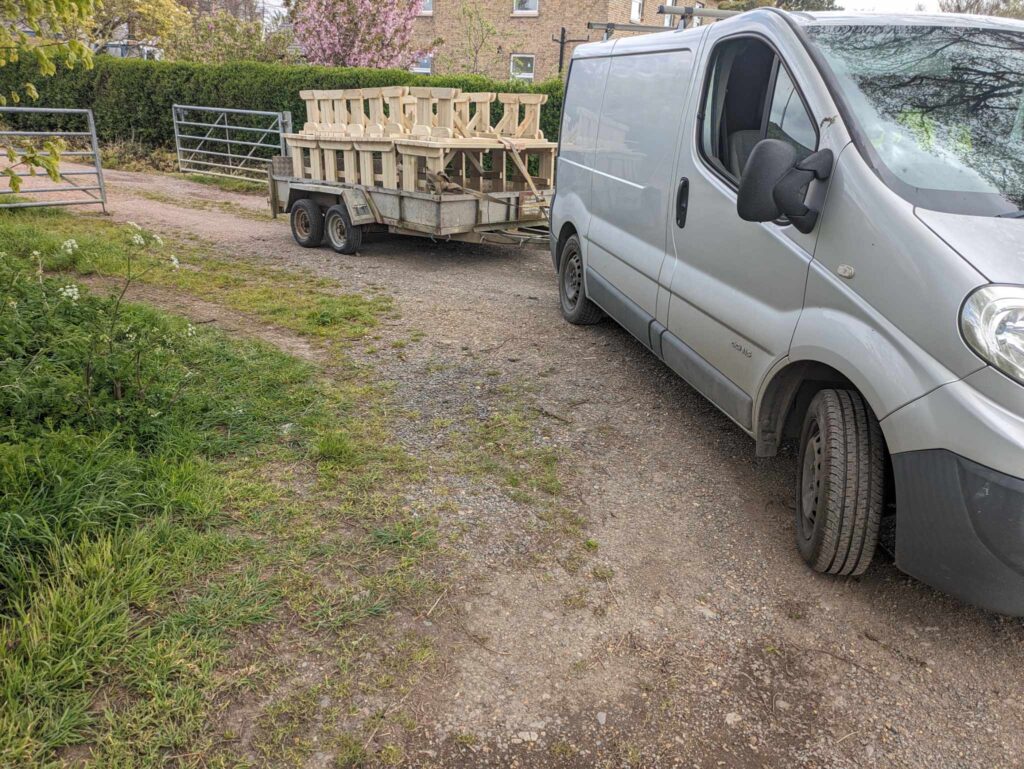 Van with a trailer, transporting picnic tables to the client’s location.