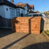 Triple bay wooden wheelie bin storage unit with hinged lids, designed for neat outdoor organization.