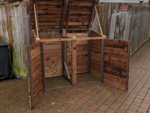Double wheelie bin storage, brown, open doors and lids.
