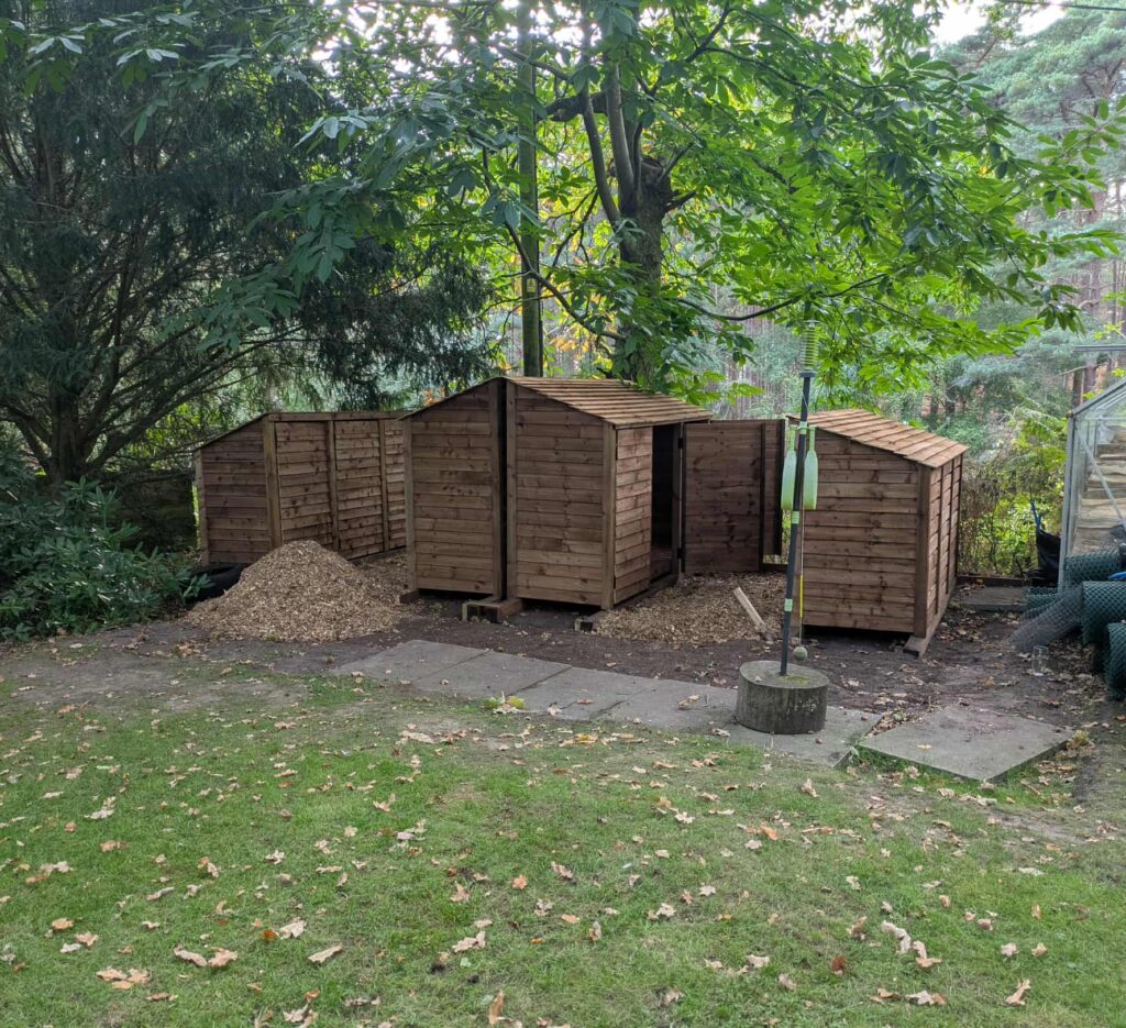 9ft deep log stores in brown with doors, different heights and roof styles